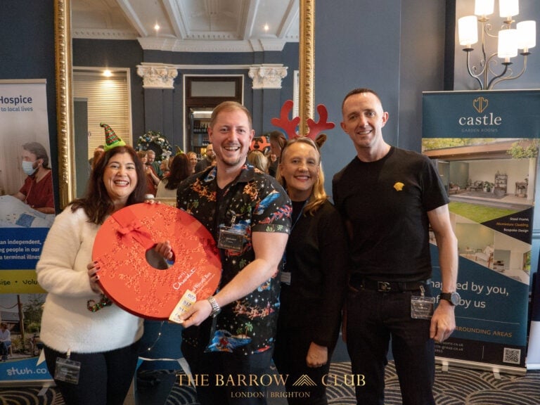 Image of the Barrow Club Xmas celebration - in the photo is Paul Britton, Jon Kennett, Christine from St Wilfreds Hospice. Jon is holding a big box of Chocolates that he won in the raffle.