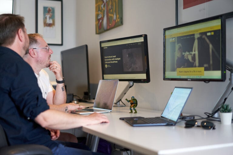 A photo of Jon and Malcolm from Bozboz looking at WordPress Websites on 2 computer screens