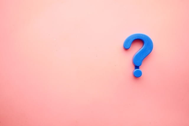 Blue question mark on pink background for building trust with website visitors blog